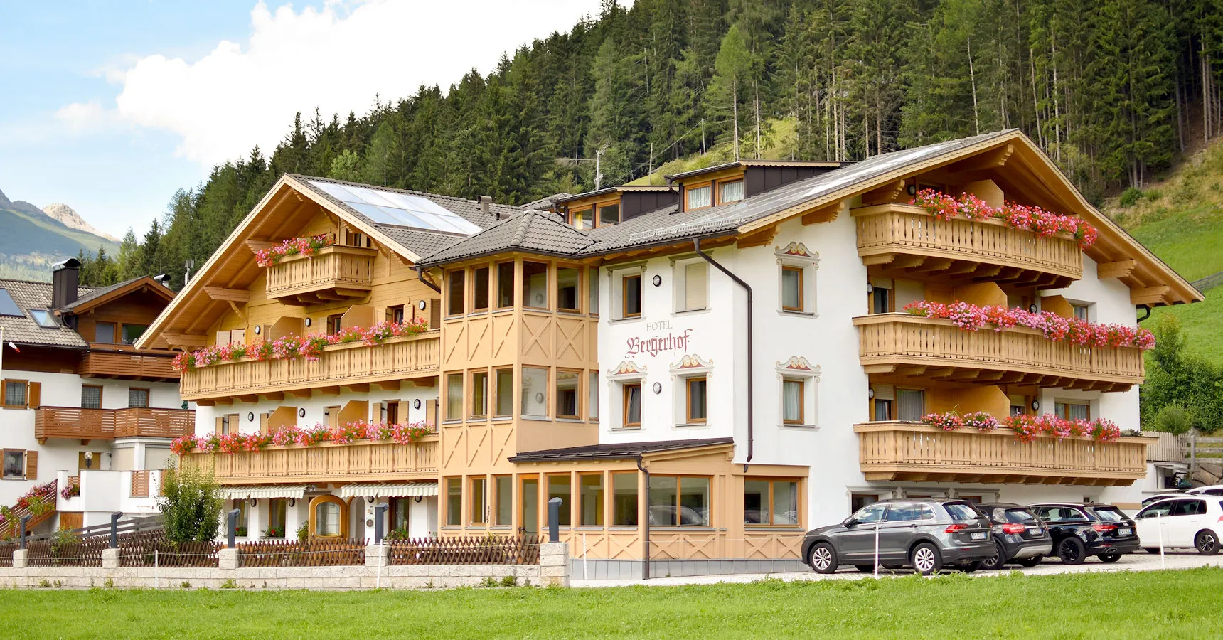 Almhotel Bergerhof mit Holzbalkonen in sonniger Berglage im Sarntal